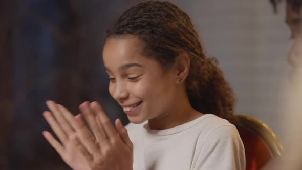 Closeup of Cheerful Teenage African American Girl Clapping Admiring Picnic Table Sitting with Family