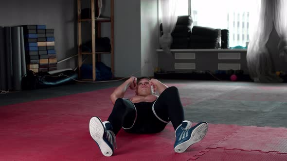 Young Man Pumping His Abs and Boxing in the Gym  Looking in the Camera