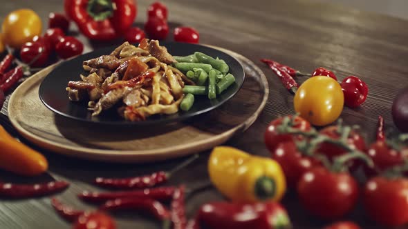 Freshly Cooked Stew on a Plate Stands on a Table Decorated with Vegetables