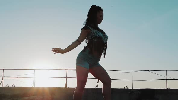 Dancing Female. silhouette happy mixed race woman dancing performance with long dreadlocks in shorts