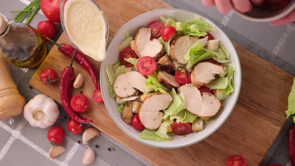 Cooking Caesar Salad Inside Deep Cooking Bowl  Adding Sliced Cherry Tomatoes