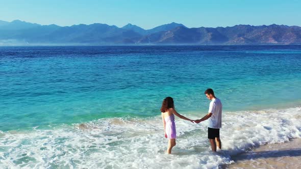 Family of two in love on beautiful seashore beach adventure by transparent ocean with white sandy ba