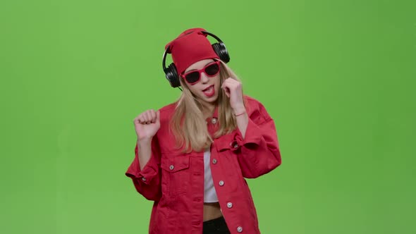 Girl Listens To Music on Headphones with Energetic Songs. Green Screen