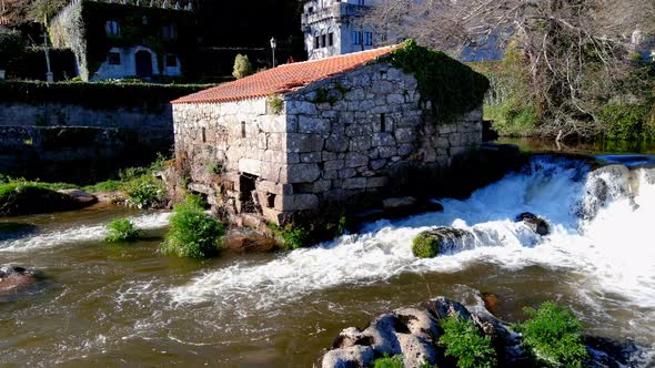 Close Up Aerial View Of Former Water Mill on the Tambre River With Water Cascading Down. Dolly Shot