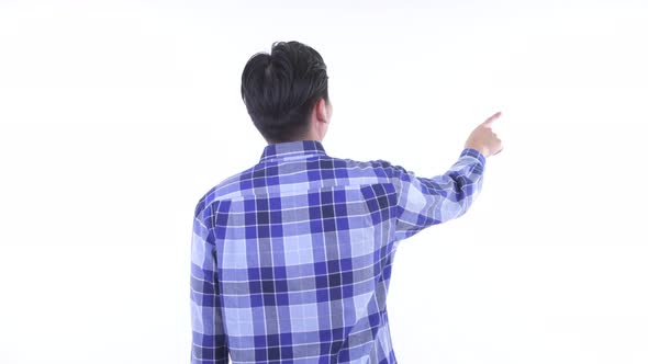 Rear View of Young Asian Hipster Man Pointing Finger