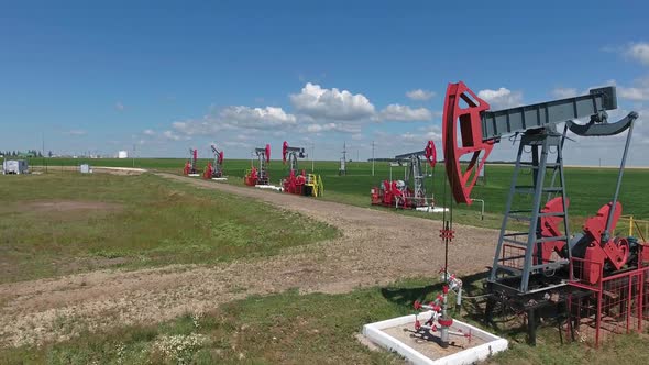 Flying Over Working Oil Pumps at Sunny Day