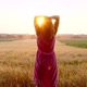 A woman at sunset walks through the field relaxing in nature. - VideoHive Item for Sale
