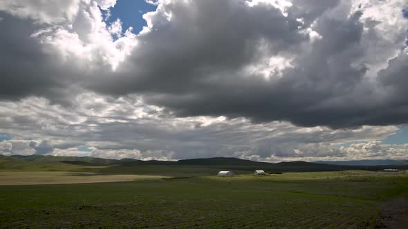 Time lapse of farm with rolling hills as clouds move through the sky