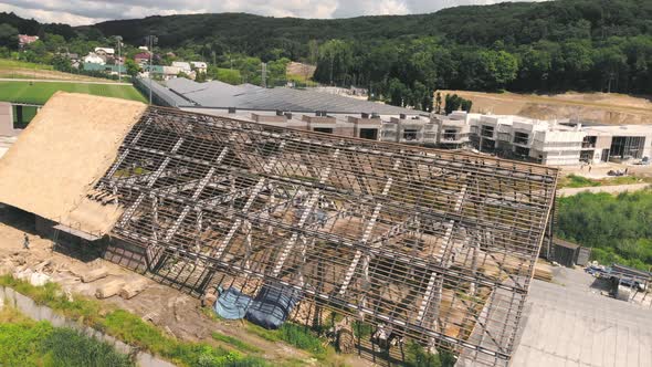 Aerial View the Roof of a Large House with Dry Straw and Hay. Workers Who Install the Roof.