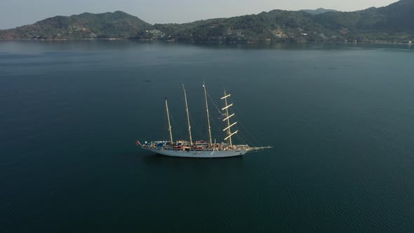 A Quadcopter Flies Over a Large White Ship In the Middle of the Ocean Near the Coast