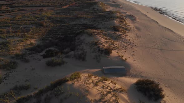 Sand dunes of Matadouro beach at sunrise in Portugal. Aerial  forward pov