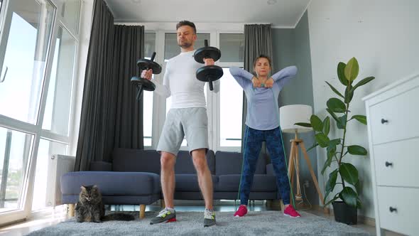 Caucasian Couple Doing Strength Training at Home in Cozy Bright Room Slow Motion