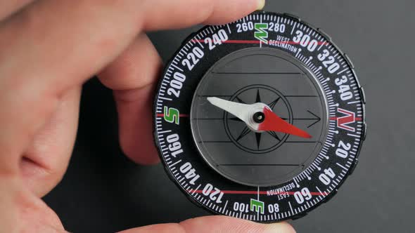 Close Up Compass with Moving Needle on Top on Black Background