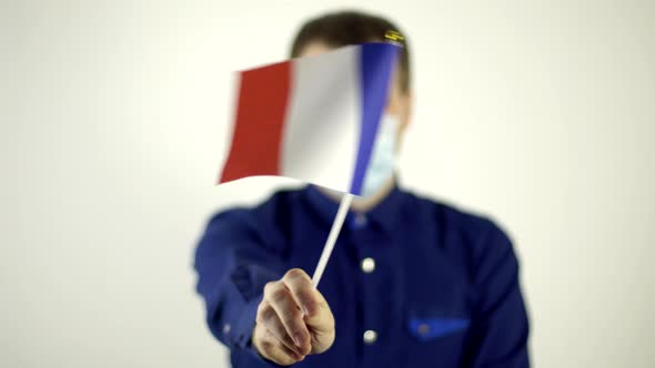 A Man in a Protective Mask on His Face Against the Virus Waving the Flag of the Country of France