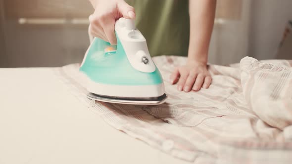 Woman Ironing a Shirt with Steam at Home