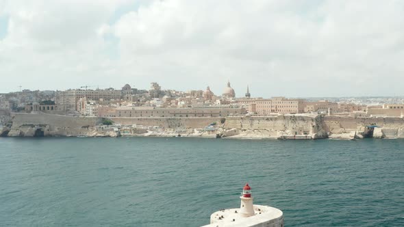 Malta Capital City Valletta From Ocean View, Aerial Dolly Forward Towards Beige City in Blue Water