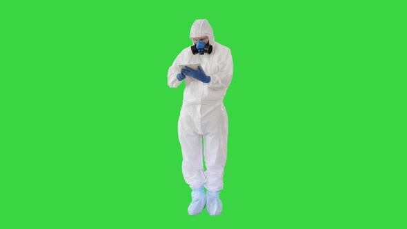 Male Doctor in Protective Suit Using Digital Tablet on a Green Screen, Chroma Key
