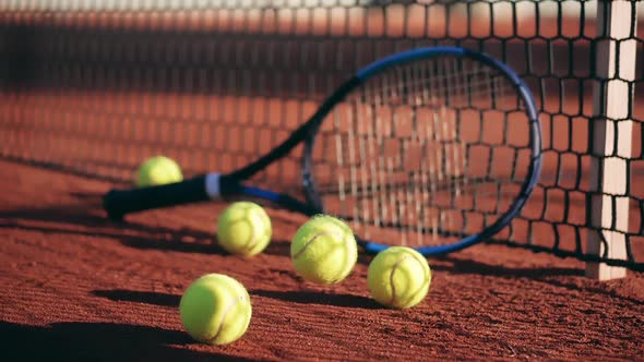 Close Up of Tennis Balls Lying Next to the Racket