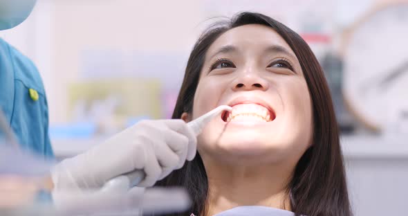 Woman dentist working at her patients teeth