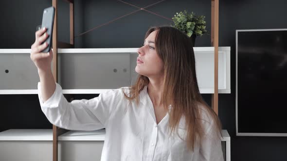 Cute Bussineswoman Tries to Connect to a Cellular Network Signal at Home in Modern Interior