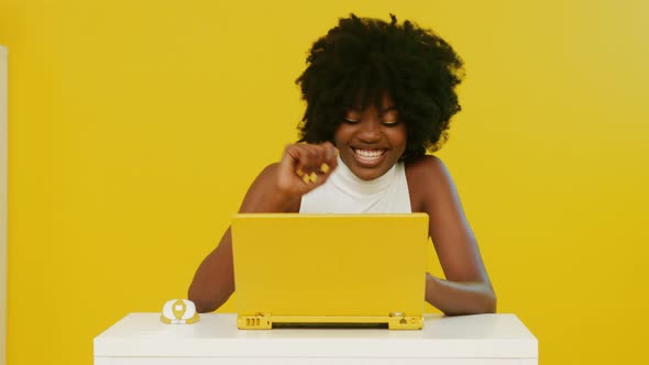 Pretty African Woman Uses Yellow Laptop