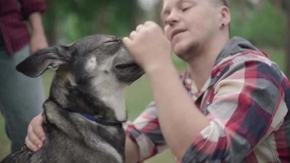 Close-up of Blurred Man Caressing Head of Domestic Dog Outdoors, Happy Smiling Pet Owner Enjoying