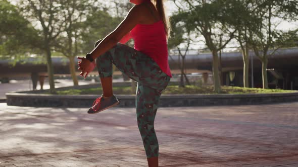 Caucasian woman stretching under a bridge