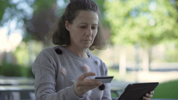 Cheerful Mature Woman Holding Credit Card and Tablet