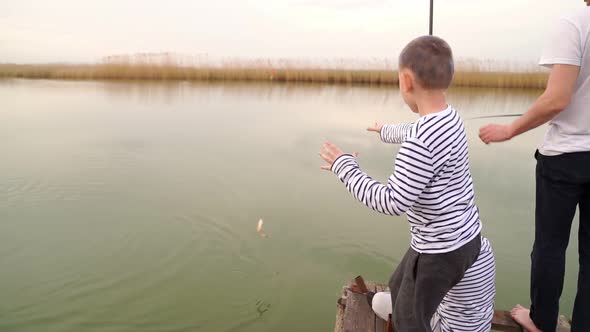 A Boy Grab a Fish Caught on a Fishing Trip
