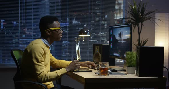 Young Man Sitting Back and Editing a Video Inside a Room