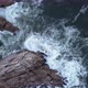 Aerial view over waves breaking onto rocks in the ocean - VideoHive Item for Sale