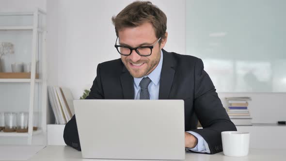 Businessman Celebrating Success, Working on Laptop