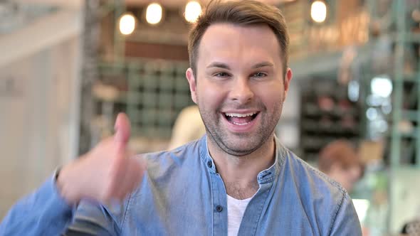 Portrait of Positive Casual Man Doing Thumbs Up