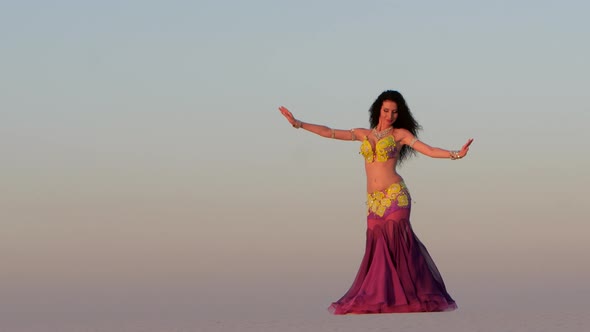 Brunette Dances Belly Dancing in the Sandy Desert, Her Movements Are Unique