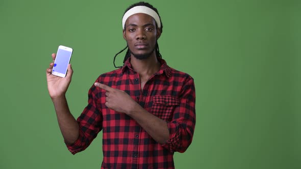 Young Handsome African Man with Dreadlocks Against Green Background