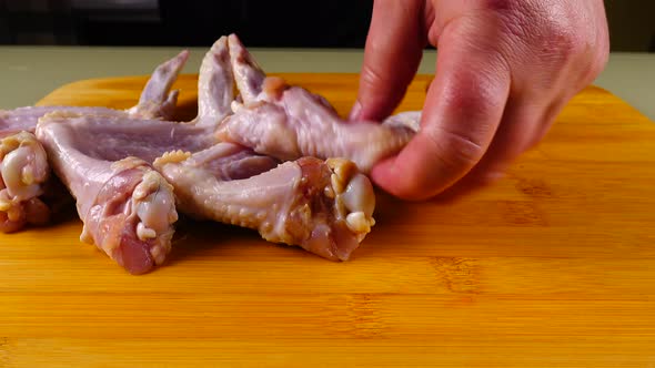 Fresh chicken wings on a cutting board.