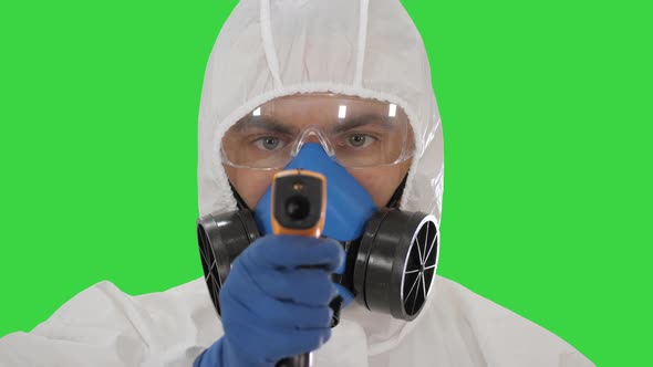 Doctor in Protective Biohazard Suit Points Laser Thermometer To Check Your Temperature at a Covid19