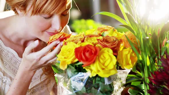 Beautiful female florist smelling roses