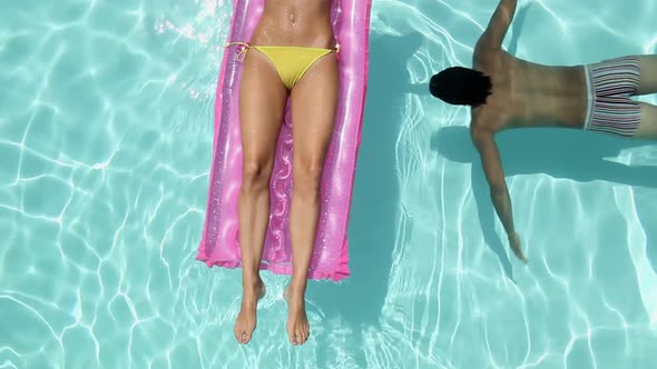 Woman Lying on Inflatable and Man Swimming Underwater in Pool