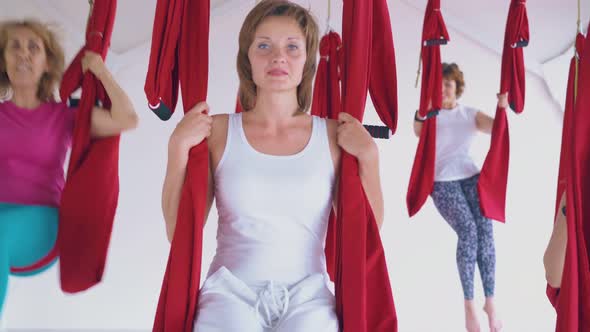 Lady Wearing White Sport Suit Relaxes After Fly Yoga Workout