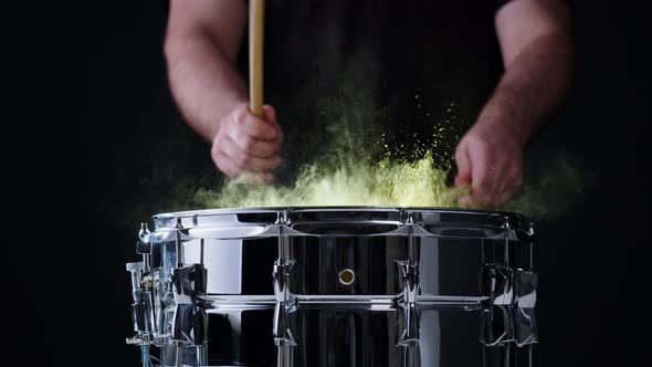 Playing Drums with Colorful Yellow Powder Closeup