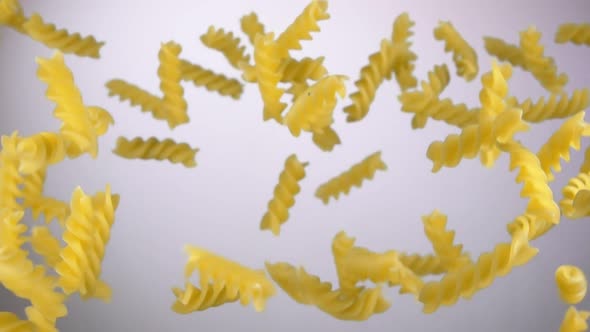 Dry Pasta Fusilli is Bouncing and Rotating on a White Background