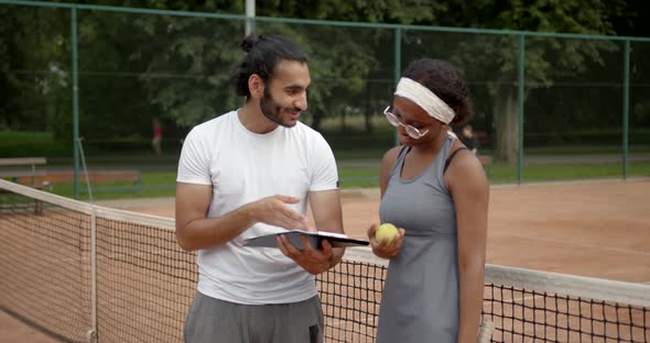 Black Woman Tennis Player and Coach on Tennis Court