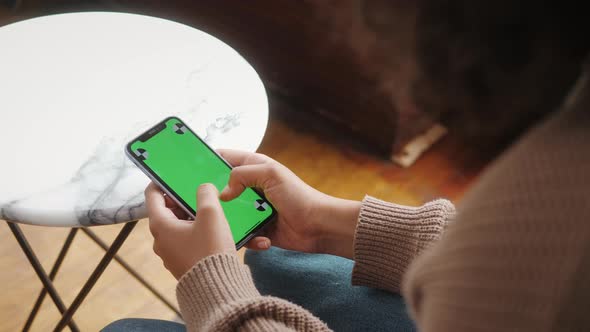 Woman Holding Mobile Phone with Green Screen Chroma Key and Marks Standing in Shopping Center Ready