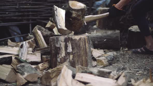 Man Chops Wood Outdoors in Slow Motion. Man's Hands Working with Ax. A Man Woodcutter Chops Tree