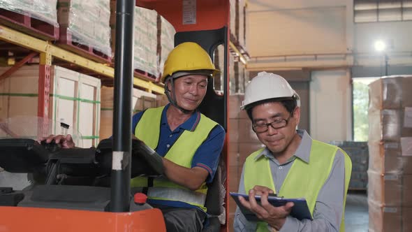 Supervisor Asian man order the forklift driver for work at the warehouse.