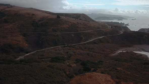 Scenic drone view of Highway 1 in northern California with coast and clouds in the background