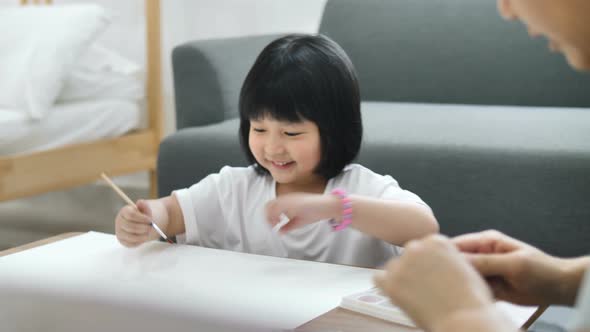 Happy Asian Mother and daughter together paint, Happiness moment at home.