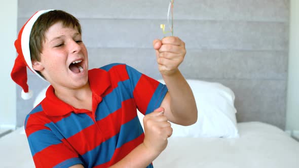 Happy boy using party popper in the bedroom