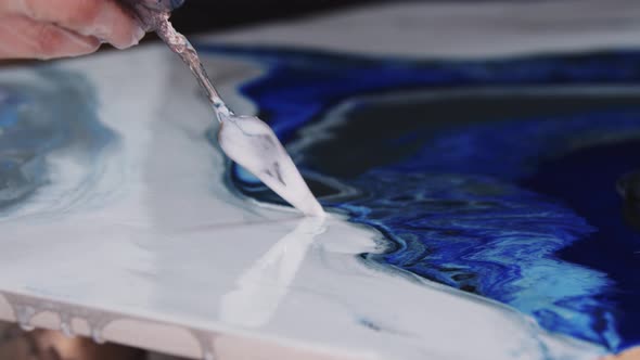 Applying White Epoxy on the Painting Using a Spatula